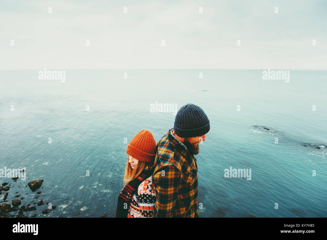 Couple in love Man and Woman back to back standing above sea Traveling together happy emotions Lifestyle concept. Young family romantic vacations Stock Photo