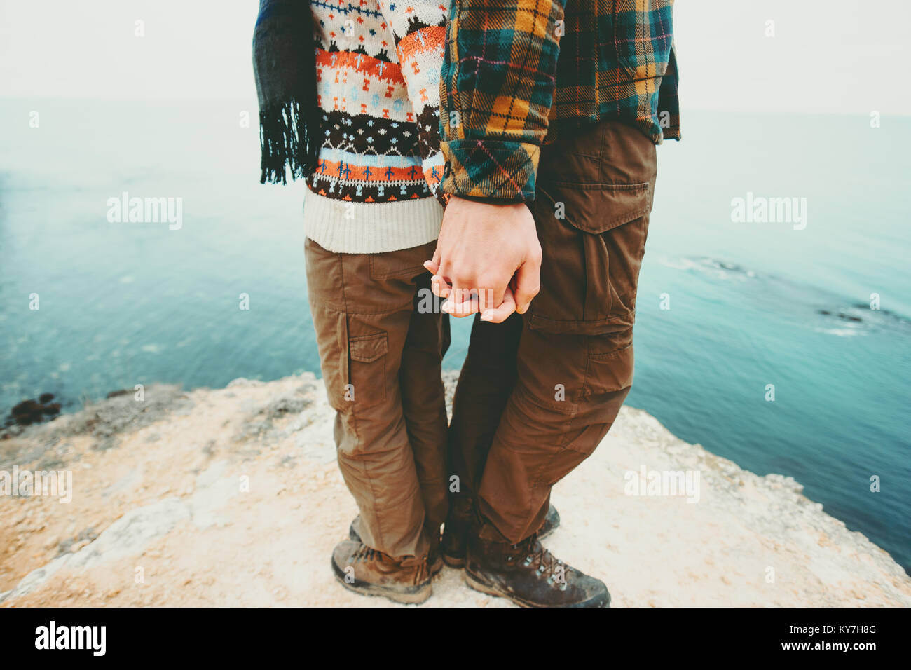 Couple Man and Woman holding hands standing on cliff above sea landscape Love and Travel happy emotions Lifestyle concept. Young family traveling roma Stock Photo