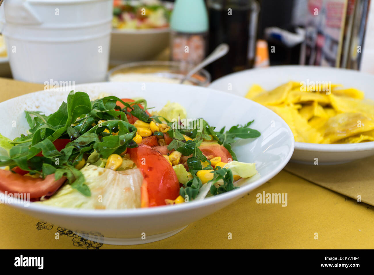 Italian-style salad, Insalata, served on a white plate in italian restaurant. Close-up. Stock Photo