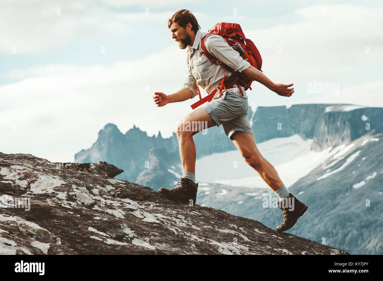 Man adventurer skyrunning in mountains with backpack Norway Travel hiking lifestyle concept