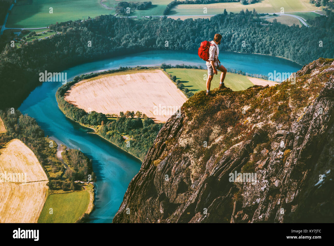 Hiking adventure in Norway mountains Man with backpack on cliff Travel lifestyle concept active weekend summer vacations river aerial view Stock Photo