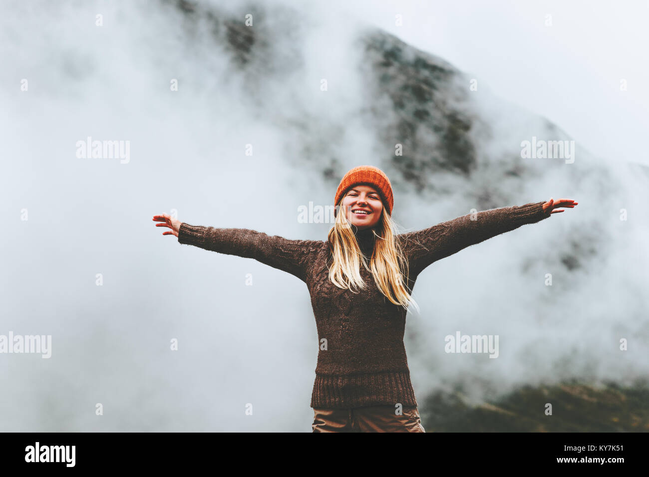 Happy woman emotional raised hands foggy mountains on background Travel Lifestyle success motivation concept adventure active vacations outdoor Stock Photo