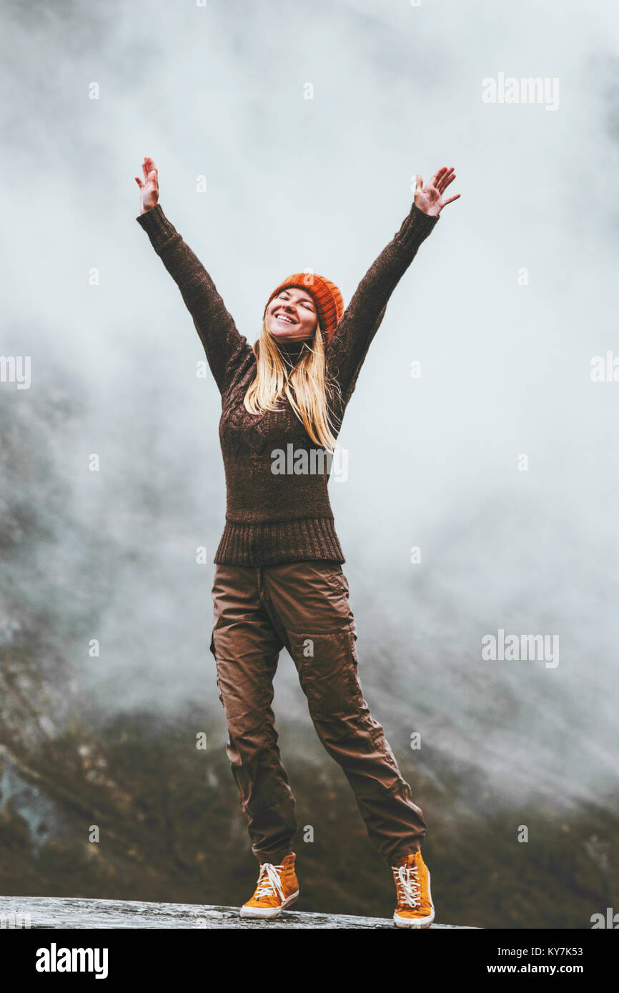 Happy woman in foggy mountains Travel Lifestyle success motivation concept adventure active vacations outdoor blessing emotions raised hands Stock Photo