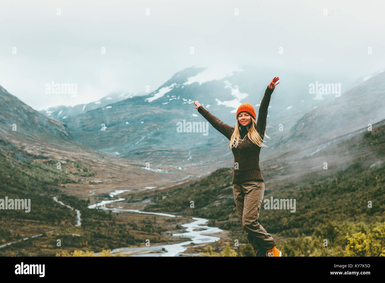 Woman traveler raised hands outdoor happy emotions foggy mountains on background Travel Lifestyle success concept adventure active vacations in Norway Stock Photo
