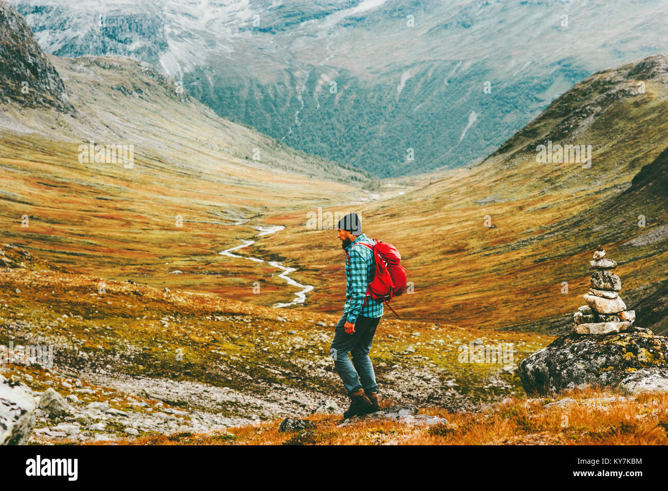 Man backpacker hiking in north mountains with backpack Travel sport lifestyle concept active weekend summer vacations wild nature in Scandinavia Stock Photo