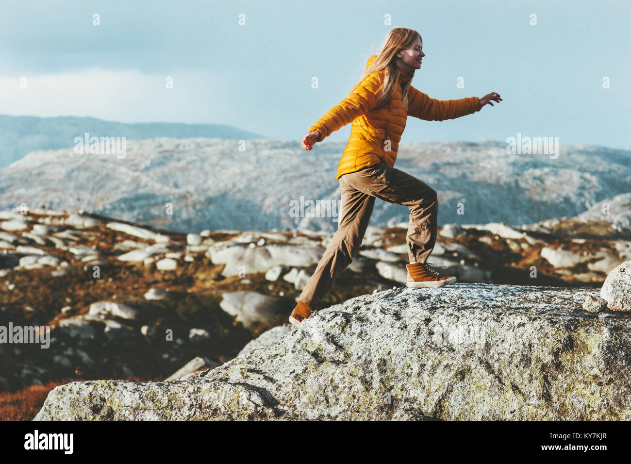 Happy Woman running outdoor in mountains Travel healthy Lifestyle concept adventure positive emotions and motivation active vacations in Norway Stock Photo