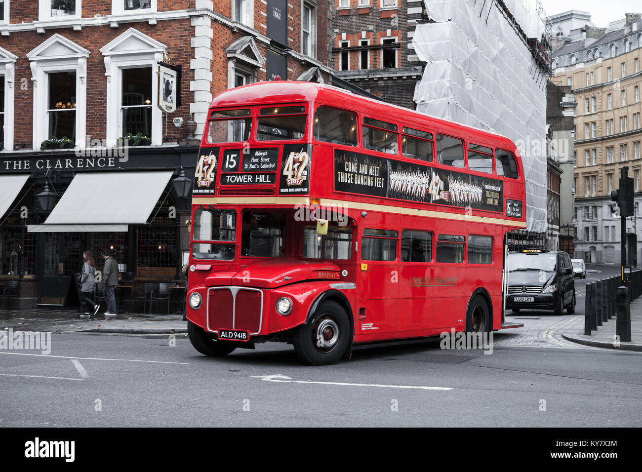 London, United Kingdom - October 21, 2017: Red double-decker bus goes on the street, one of the most popular symbols of the city. Ordinary people walk Stock Photo