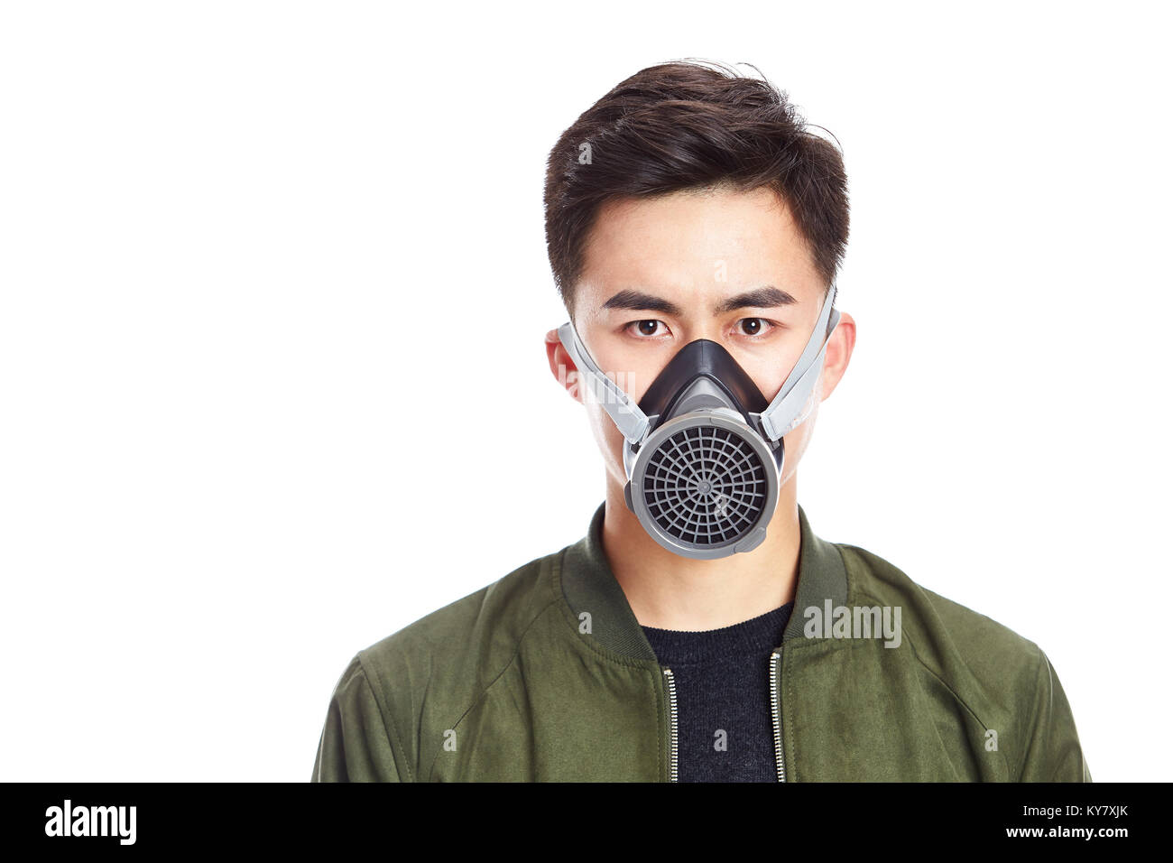 studio shot of a young asian man wearing a gas mask, looking at camera, isolated on white background. Stock Photo