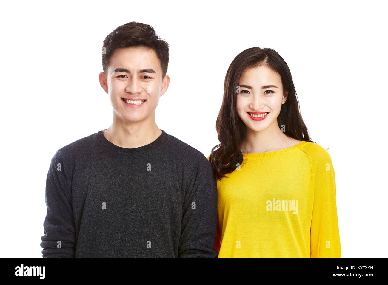 studio portrait of a young asian couple happy and smiling looking at ...