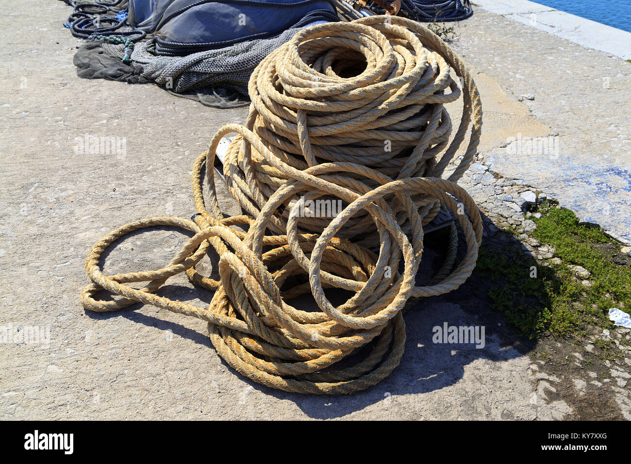 Fishermans coiled rope on quayside Stock Photo