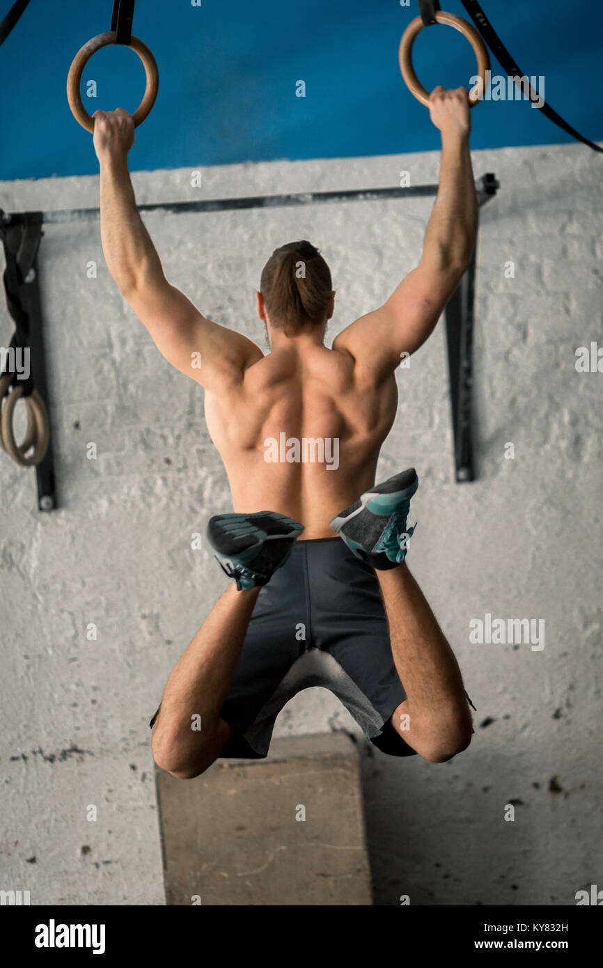 Muscleup exercise athletic man doing intense workout at gym on