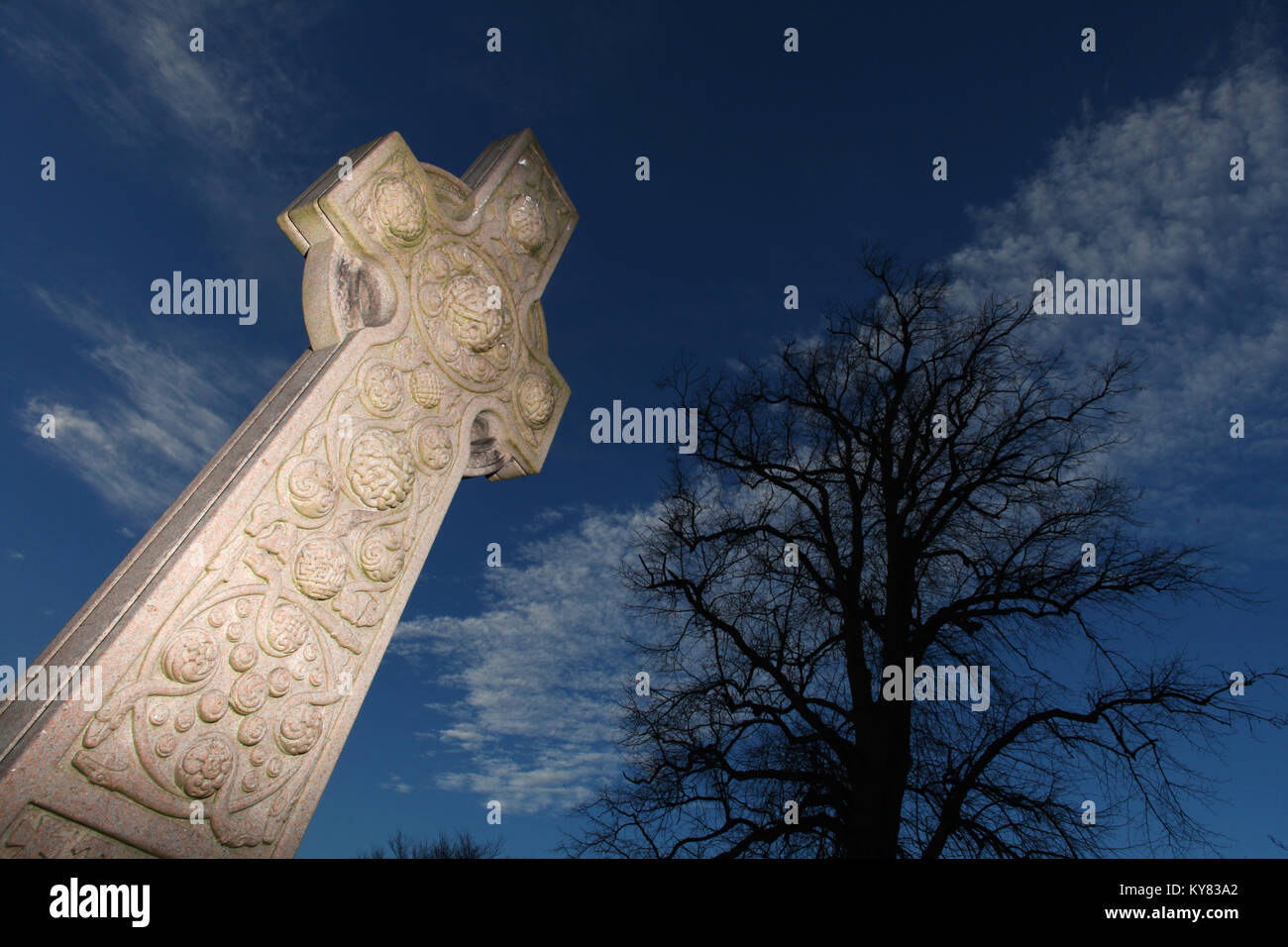 a celtic design gravestone situated in the graveyard of corstorphine old parish church set against the silhouette of a nearby tree Stock Photo