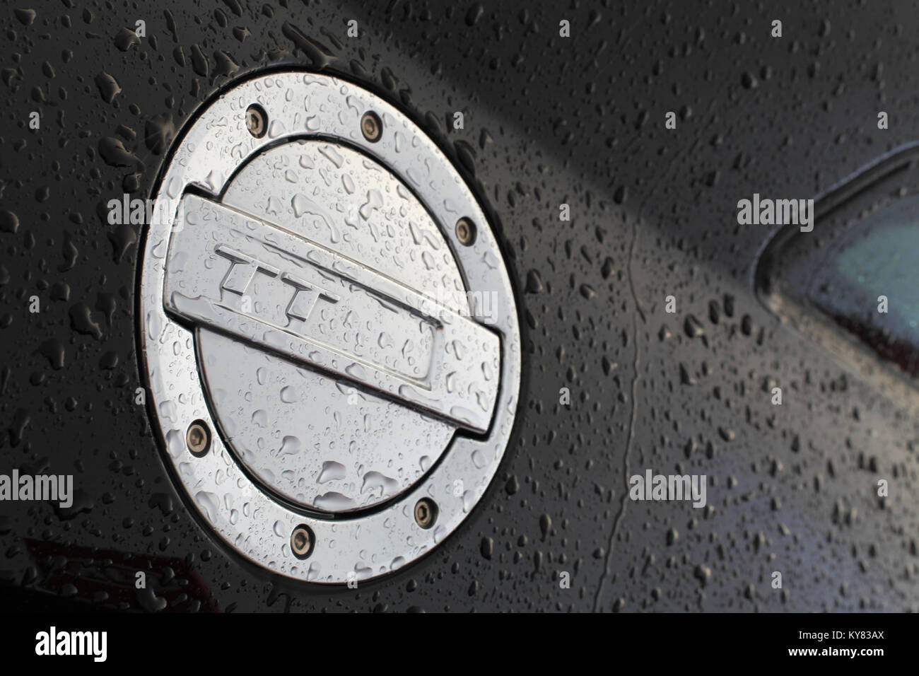 An Audi TT fuel cap cover covered in water droplets due to rainfall Stock Photo
