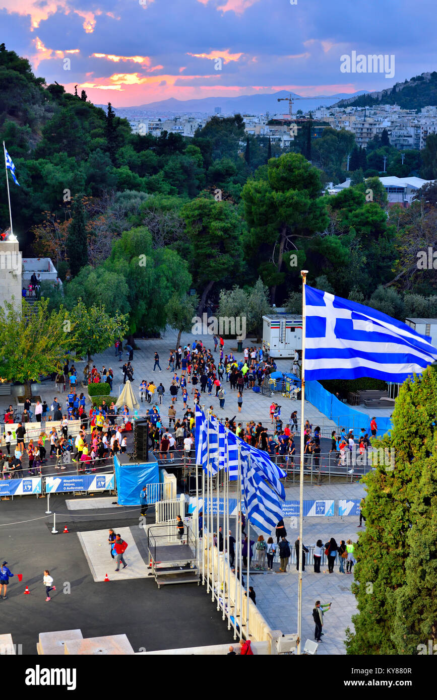 Night inside the Panathenaic Stadium at end of sporting event with view Greek flags and city skyline Stock Photo