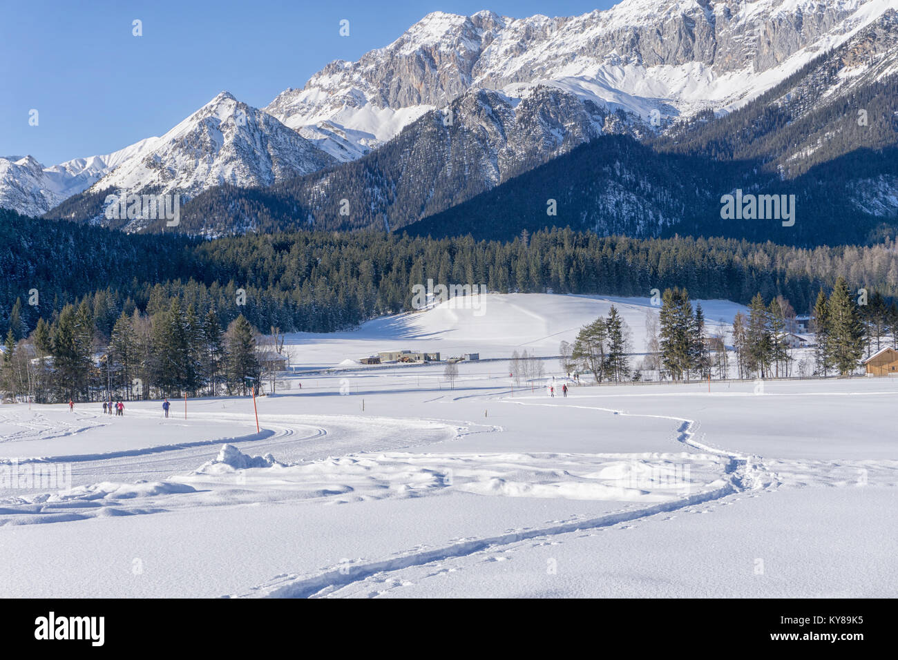 Winter mountains landscape with groomed ski track and blue sky in sunny day Stock Photo
