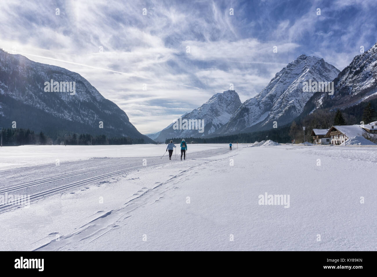 Winter mountains landscape with groomed ski track and blue sky with white clouds Stock Photo