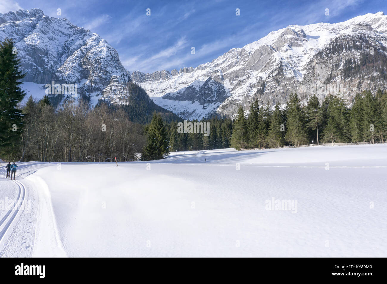 Winter mountains landscape with groomed ski track and blue sky in sunny day Stock Photo