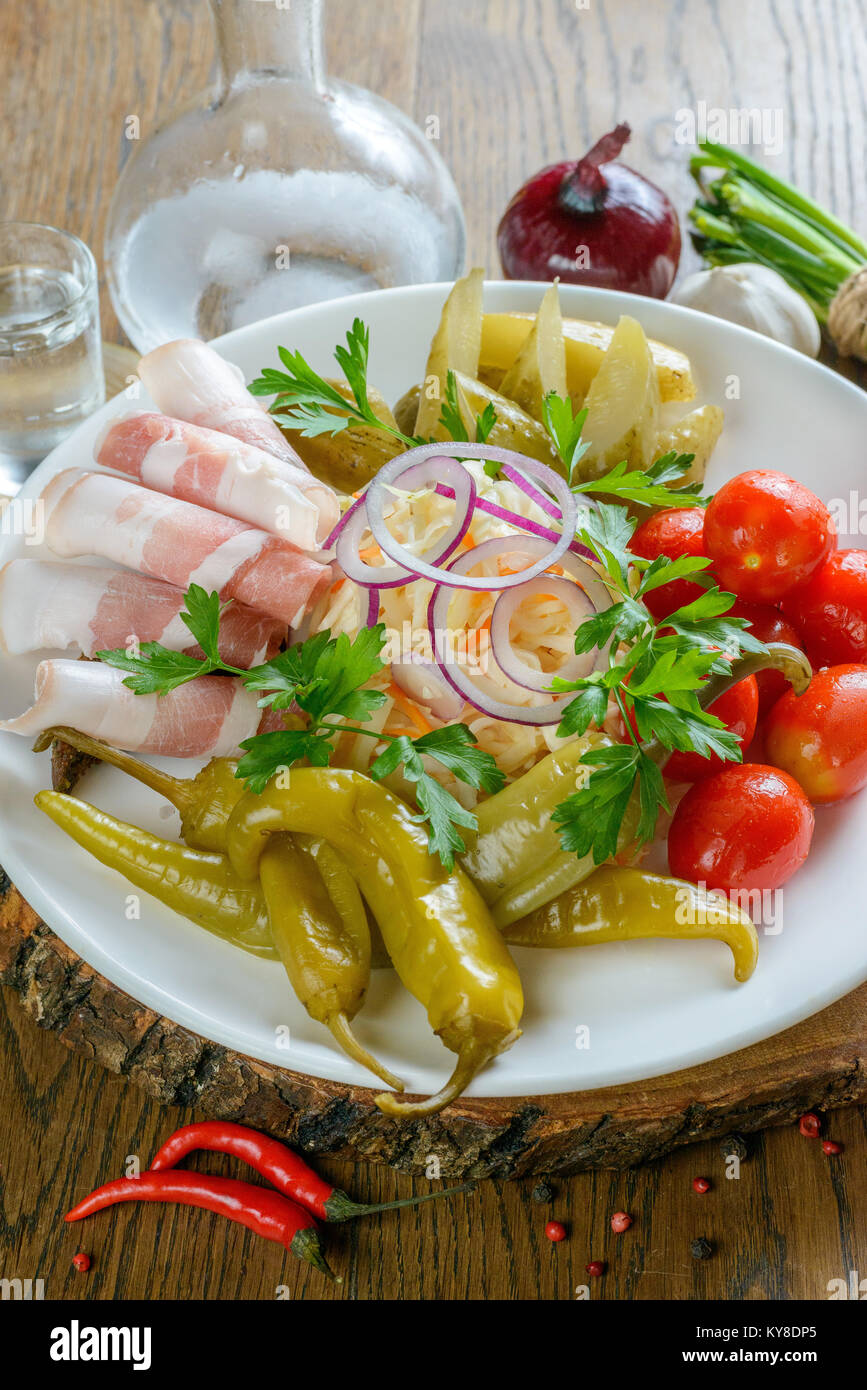Appetizing lard and pickled vegetables garnished on white plate Stock Photo