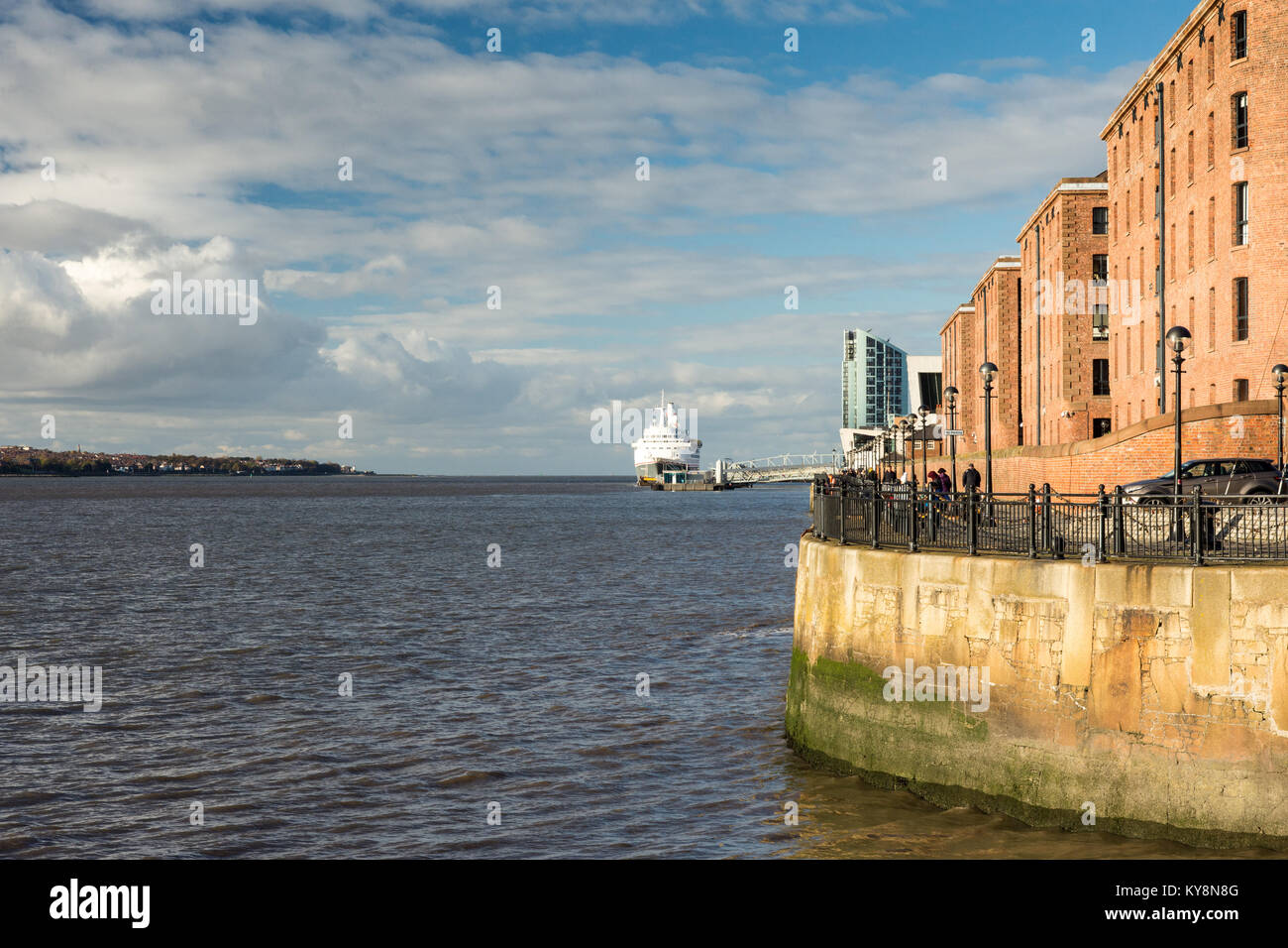 Liverpool, England, UK - November 11, 2016: Sun shines on the redeveloped Albert Dock warehouses in Liverpool's historic docks, with a cruise ship doc Stock Photo