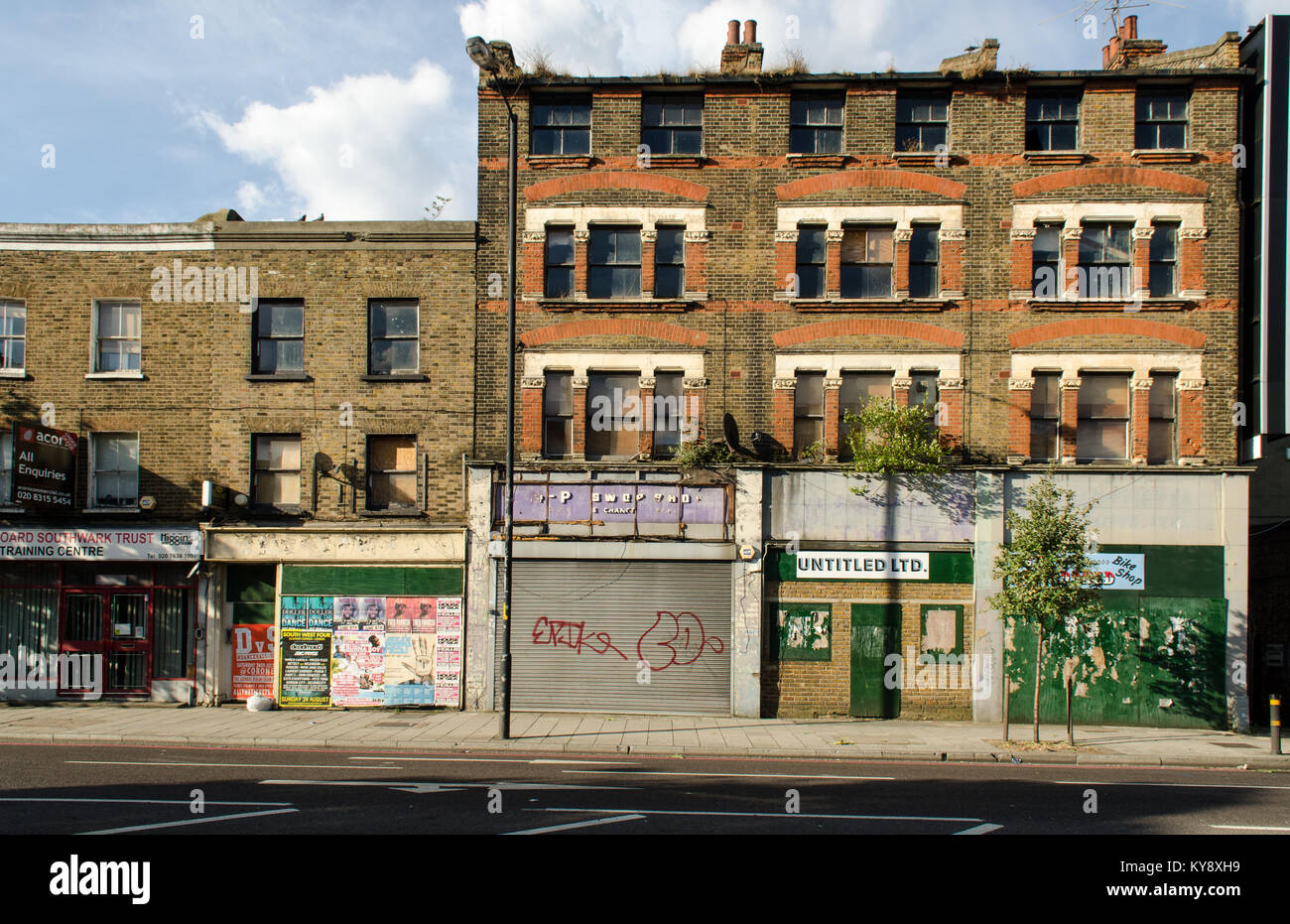 London, England, UK - July 9, 2014: Scruffy shops occupy run-down buildings on the busy Old Kent Road in south east London, a major urban regeneration Stock Photo