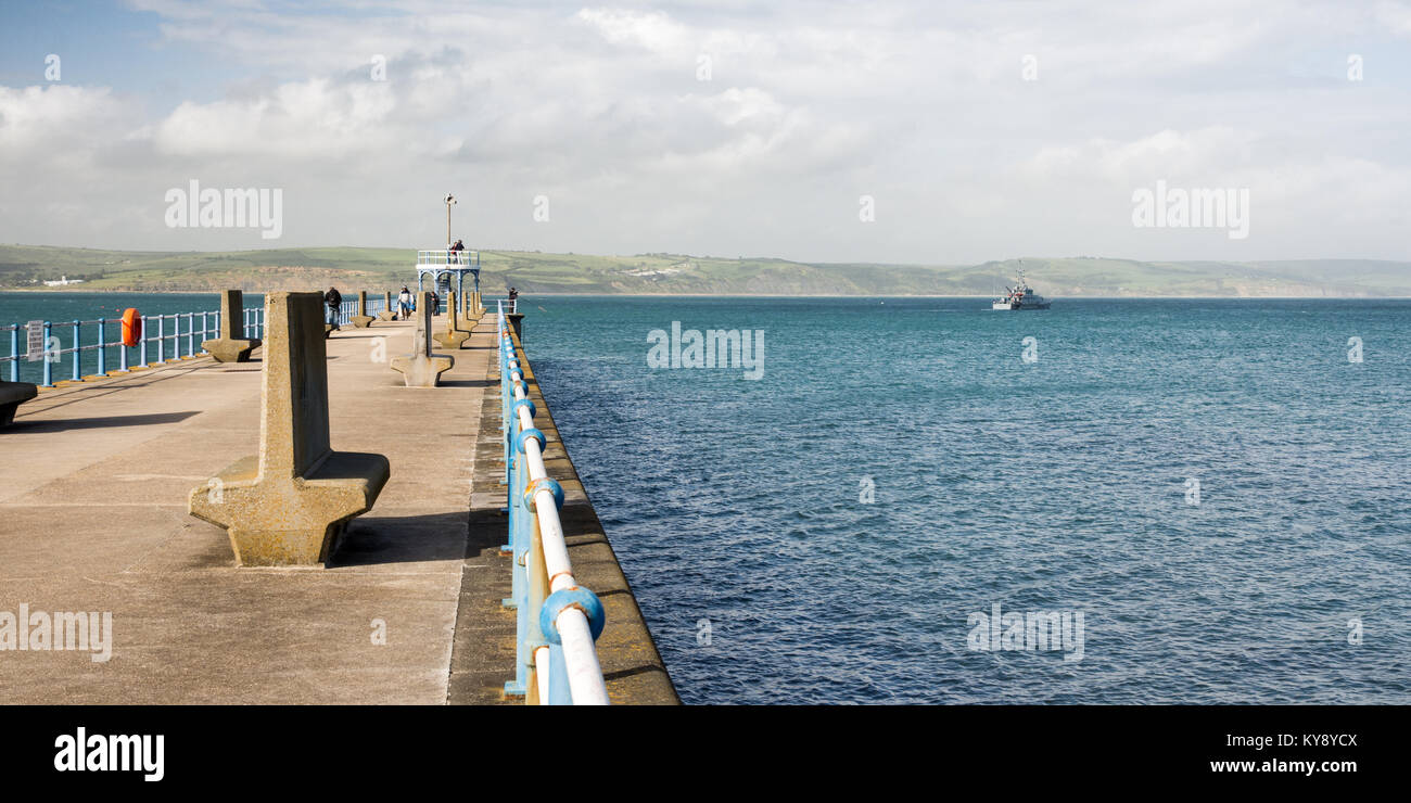 UK Border Agency customs cutter HMC Valiant passes the Stone Pier leaving Weymouth Harbour in Dorset. Stock Photo