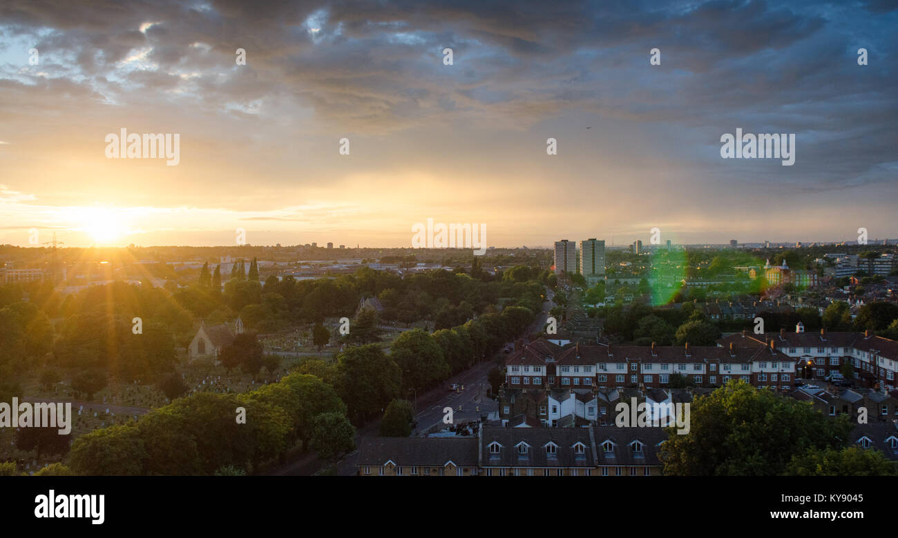 Sunset under stormy skies in Tooting, south west London, with Blackshaw Road and Lambeth Cemetery leading into a cityscape seen from the 13th floor of Stock Photo