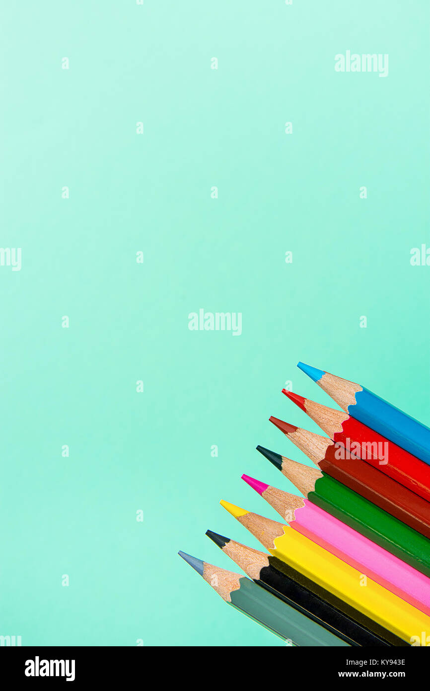 Row of Multicolored Pencils Crayons on Turquoise Background. Business Creativity Graphic Design Crafts Kids School Drawing Blogging Concept. Copy Spac Stock Photo