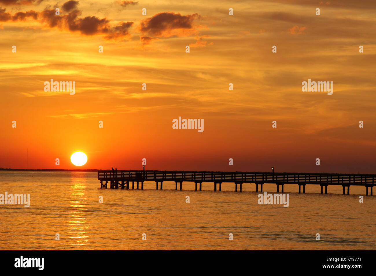 Charlotte Harbor sunset with golden sky and silhouetted fishing pier, Florida USA. Stock Photo