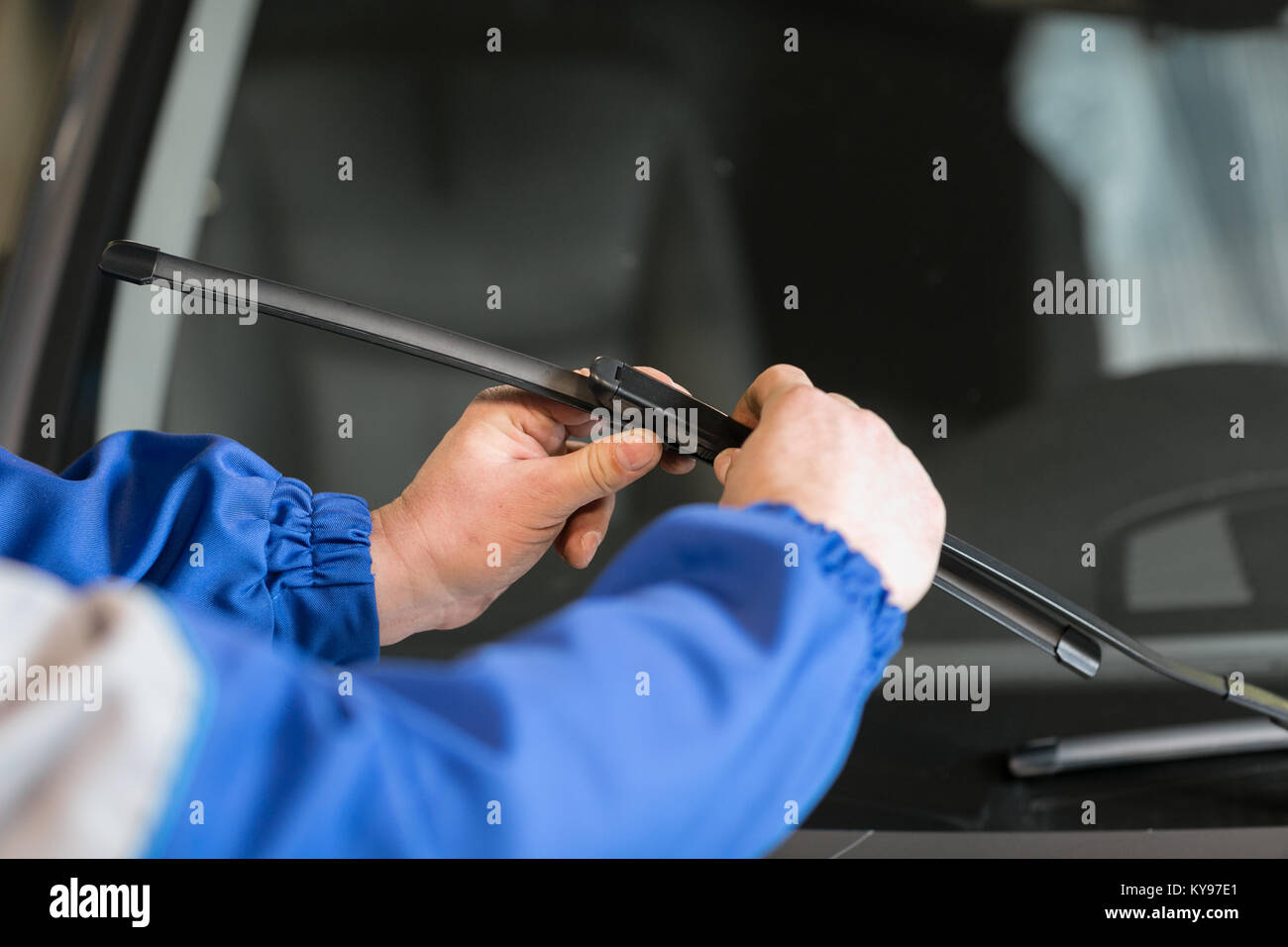 Technician is changing windscreen wipers on a car station Stock Photo
