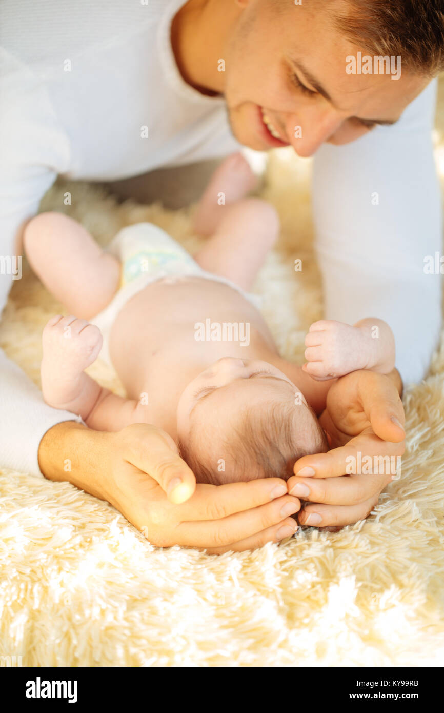 Father lying on bed and holds his baby Stock Photo - Alamy