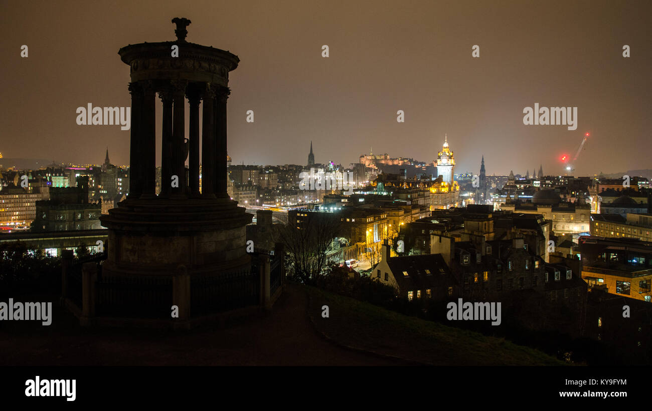 Edinburgh, Scotland, UK - March 19, 2015: Edinburgh Old Town and castle are lit up at night, as viewed from beside the Dugald Stewart Memorial on Calt Stock Photo