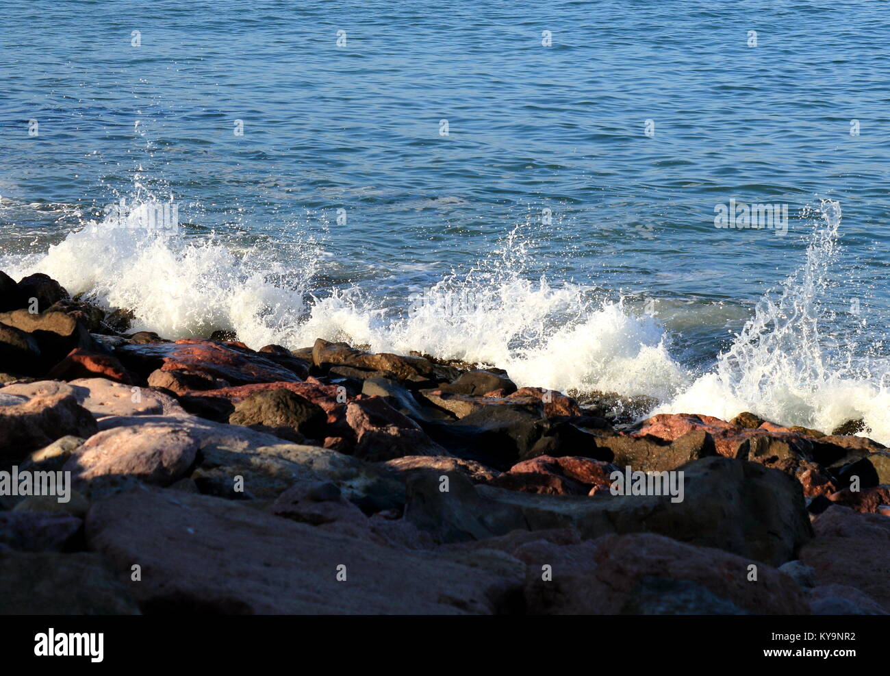 Waves splashing against rocky shore Stock Photo - Alamy