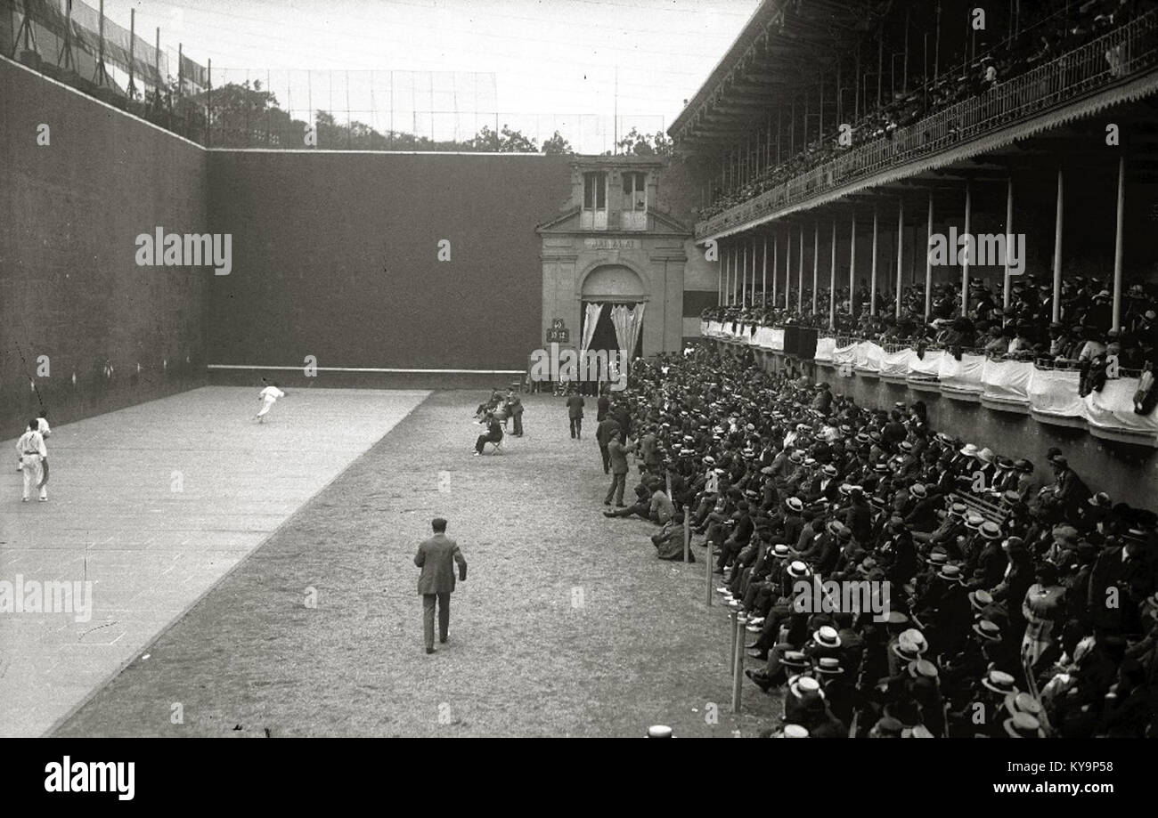 The image shows a game of Jai Alai played at a frontón court ...