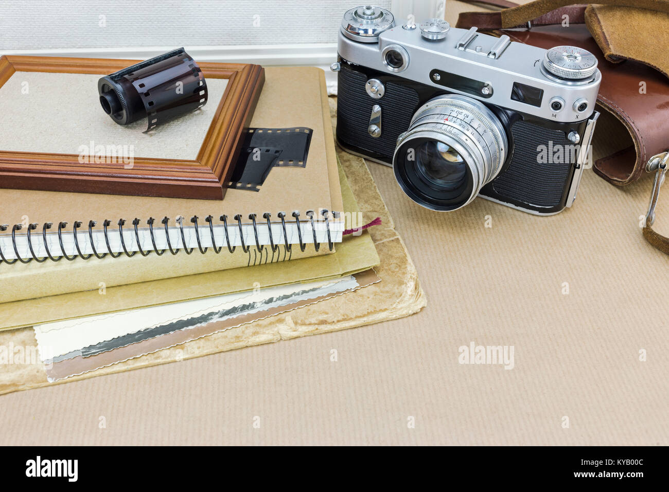 nostalgia concept. classic camera, photo frame, old pictures and film roll on kraft paper background. Stock Photo