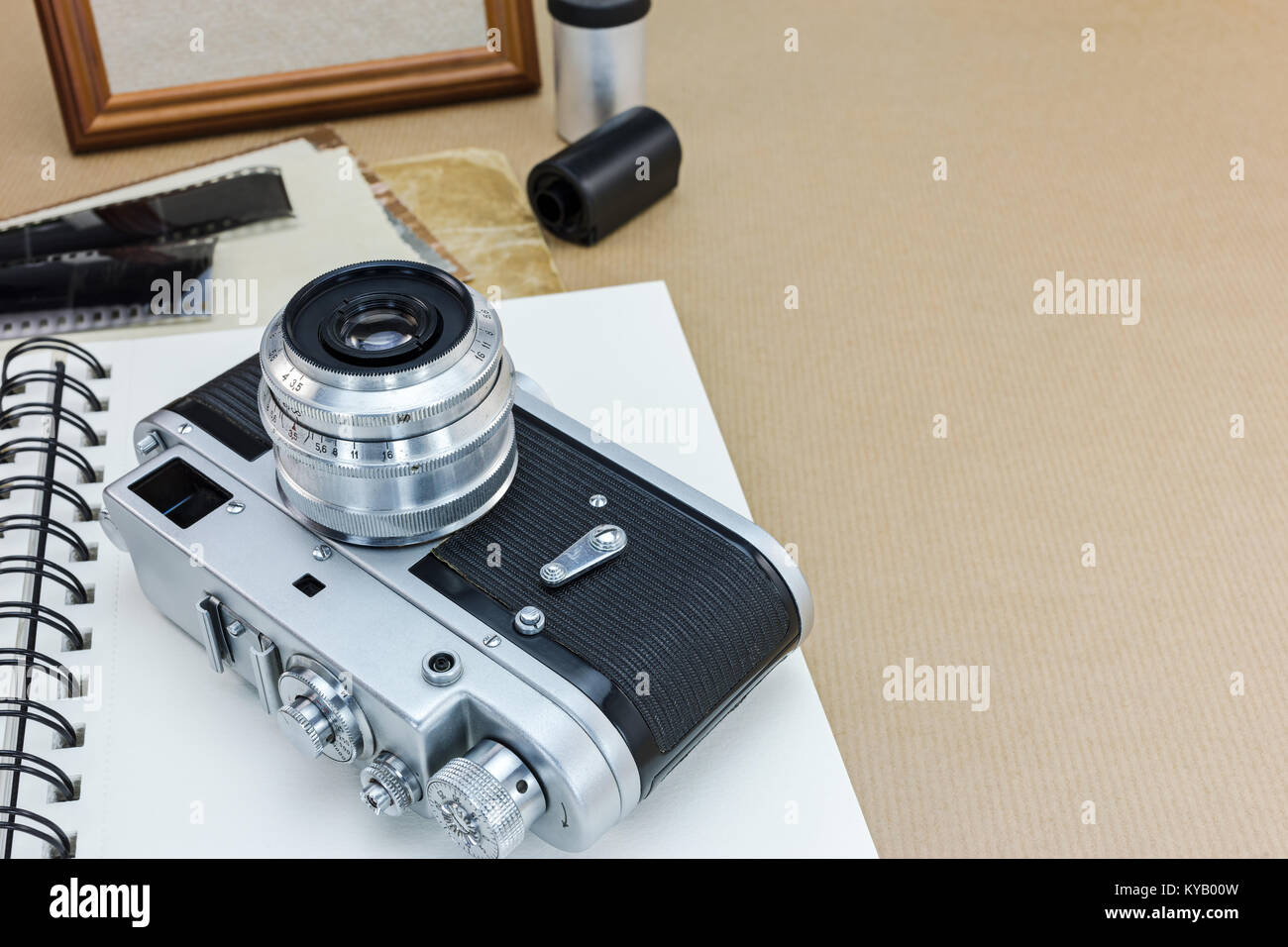 retro camera, notebook, photo frame and old pictures on table