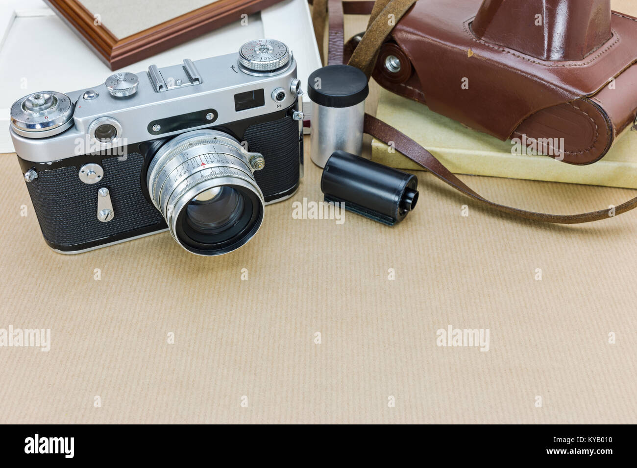 classic camera with brown leather case, photo frames and film rolls on ...