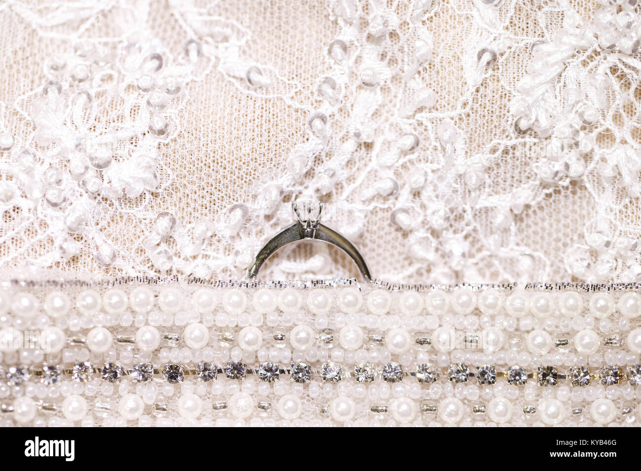 Wedding ring with a diamond on wedding dress background Stock Photo - Alamy