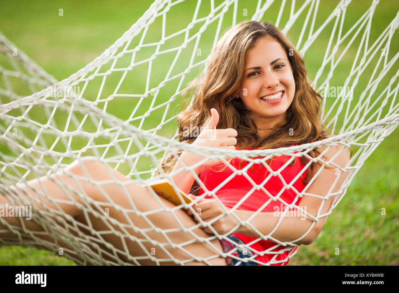 Girl lying in hammock and reading a book Stock Photo - Alamy