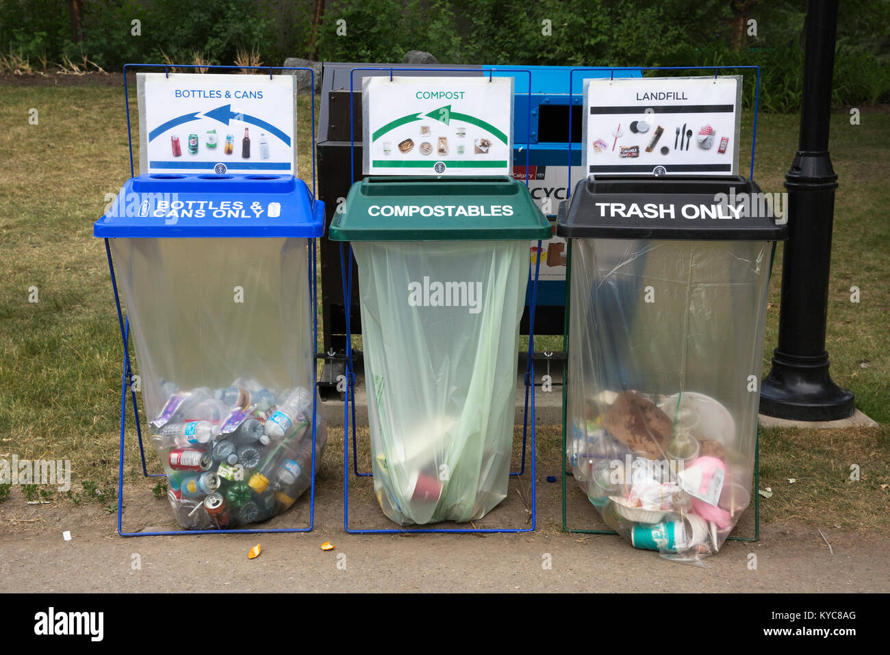 Disposal bins for bottles and cans recycling, compostables and trash in a green city. Stock Photo
