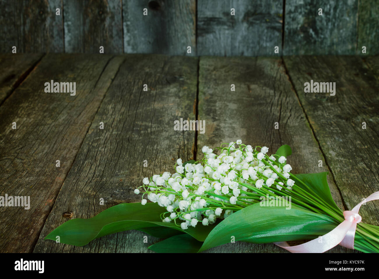 lilies of the valley closeup on the old wooden background blurred ...