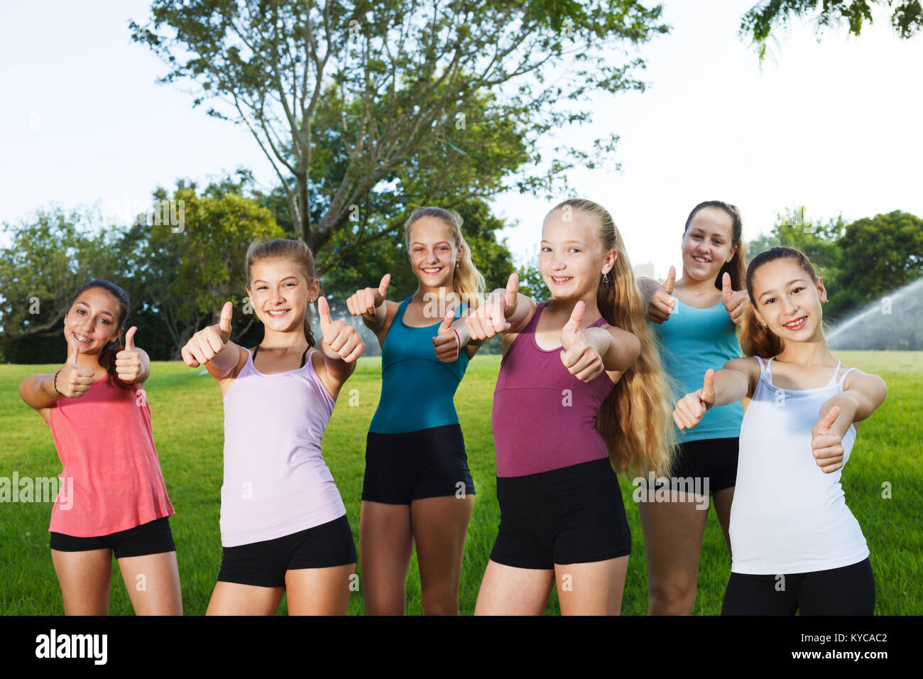 Happy girls holding thumbs up at summer camp Stock Photo