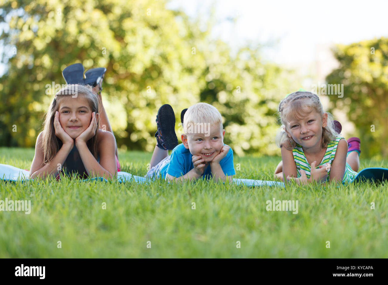 Happy children lying in grass Stock Photo