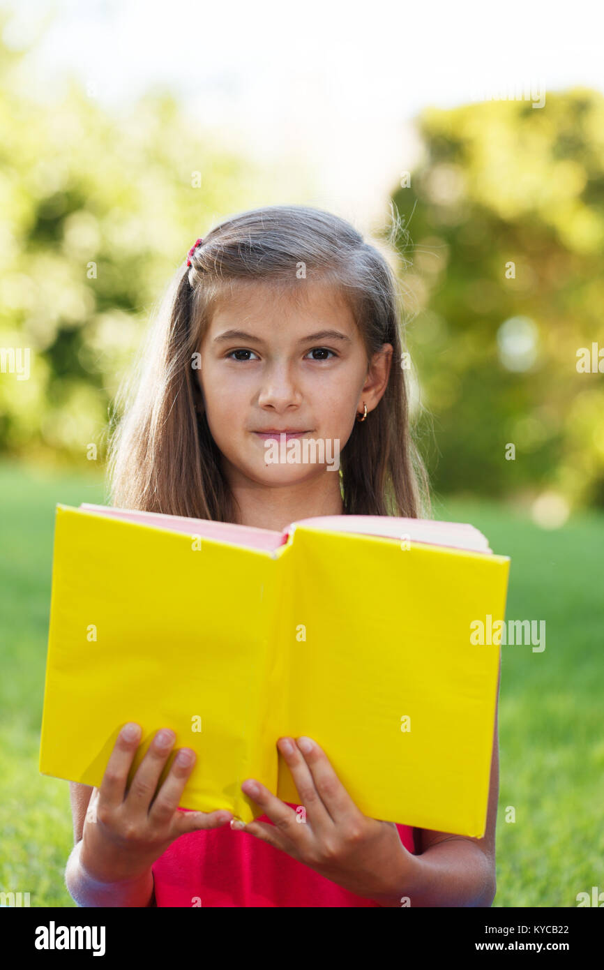 Little girl hold yellow book Stock Photo Alamy