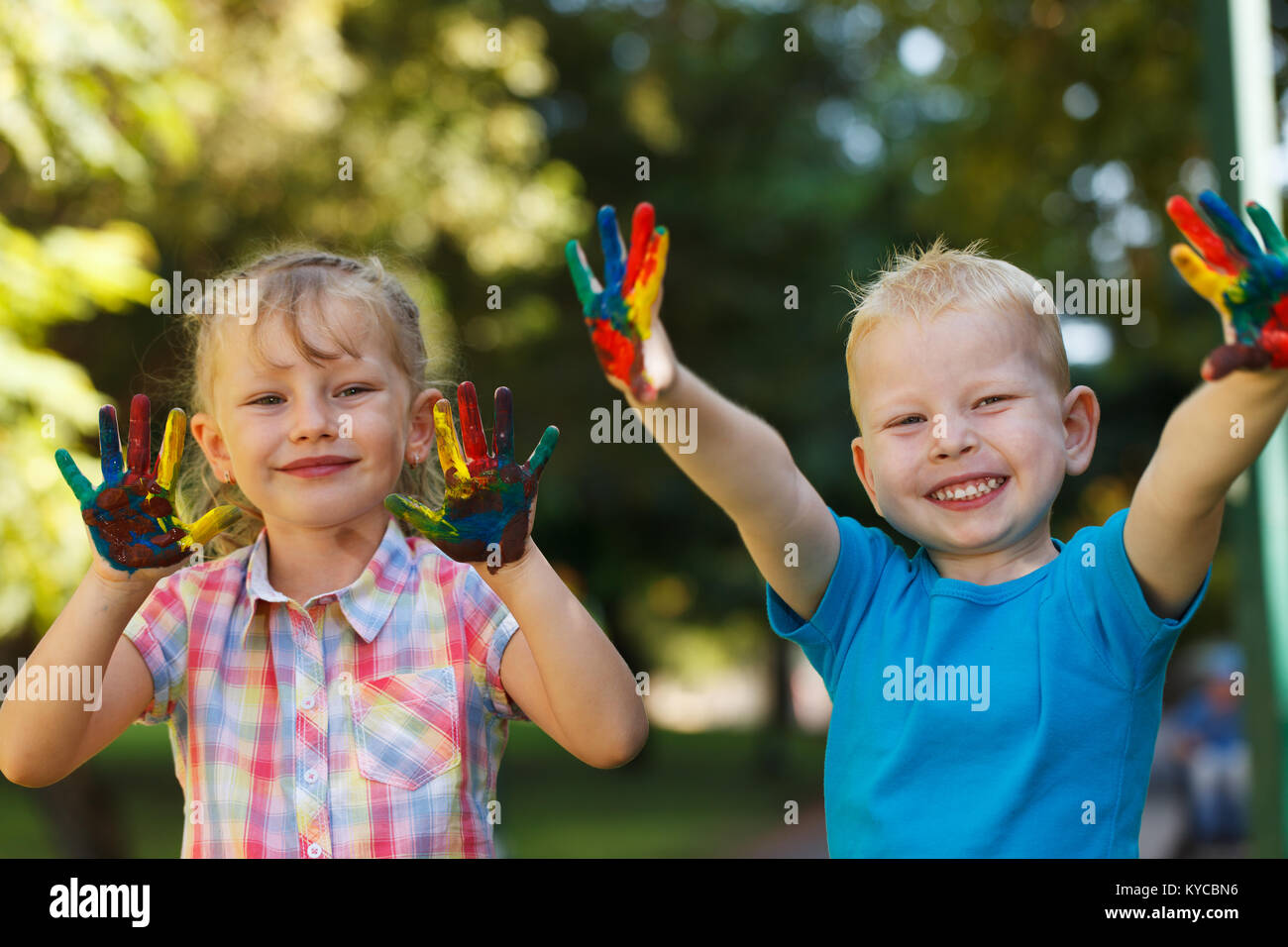 Two kids with hands colored in paint Stock Photo