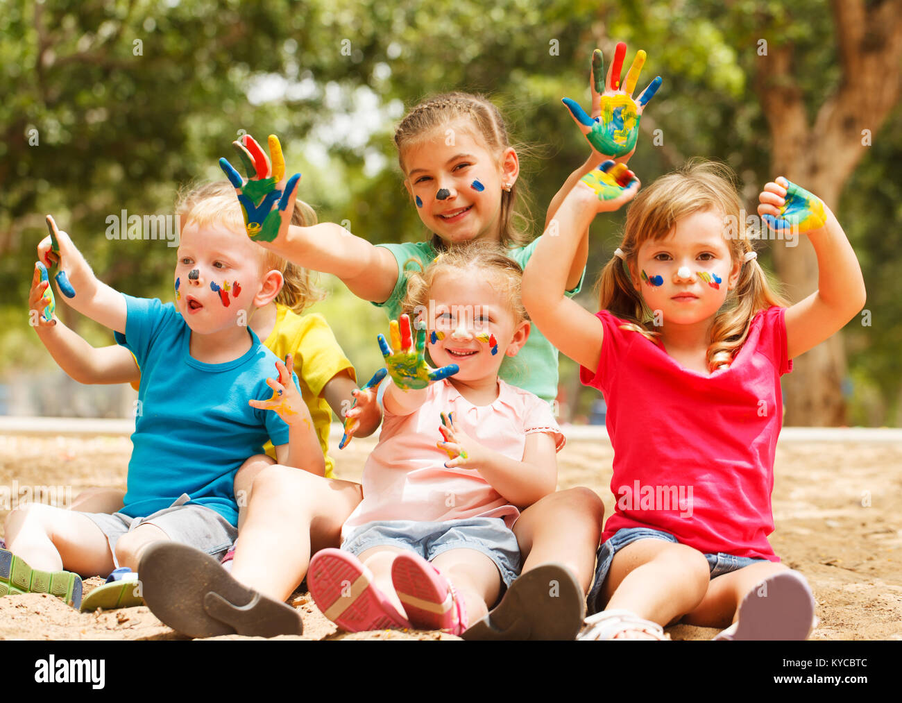 Five happy kids with hands covered in paint Stock Photo