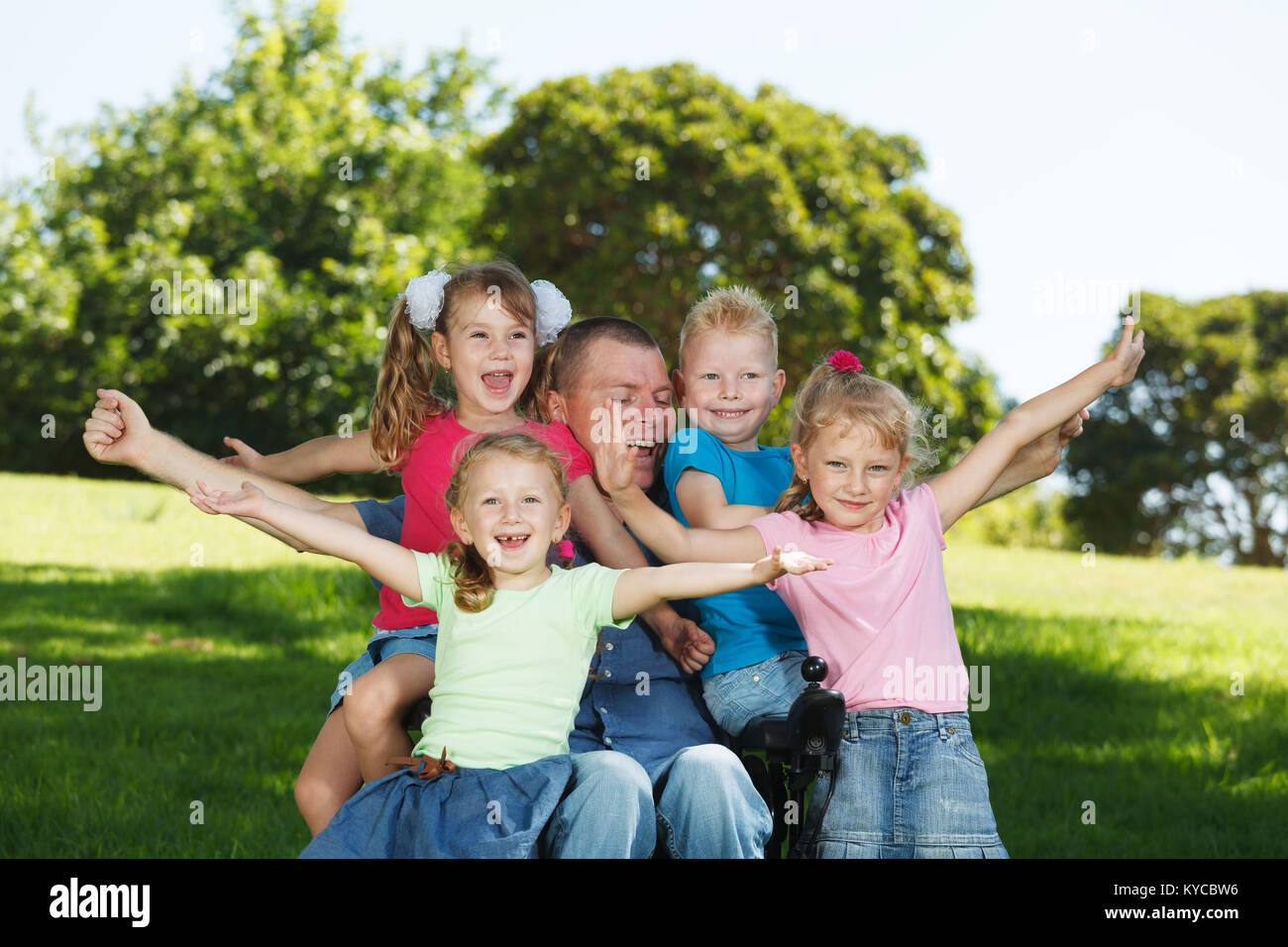 Disabled father with children showing freedom Stock Photo