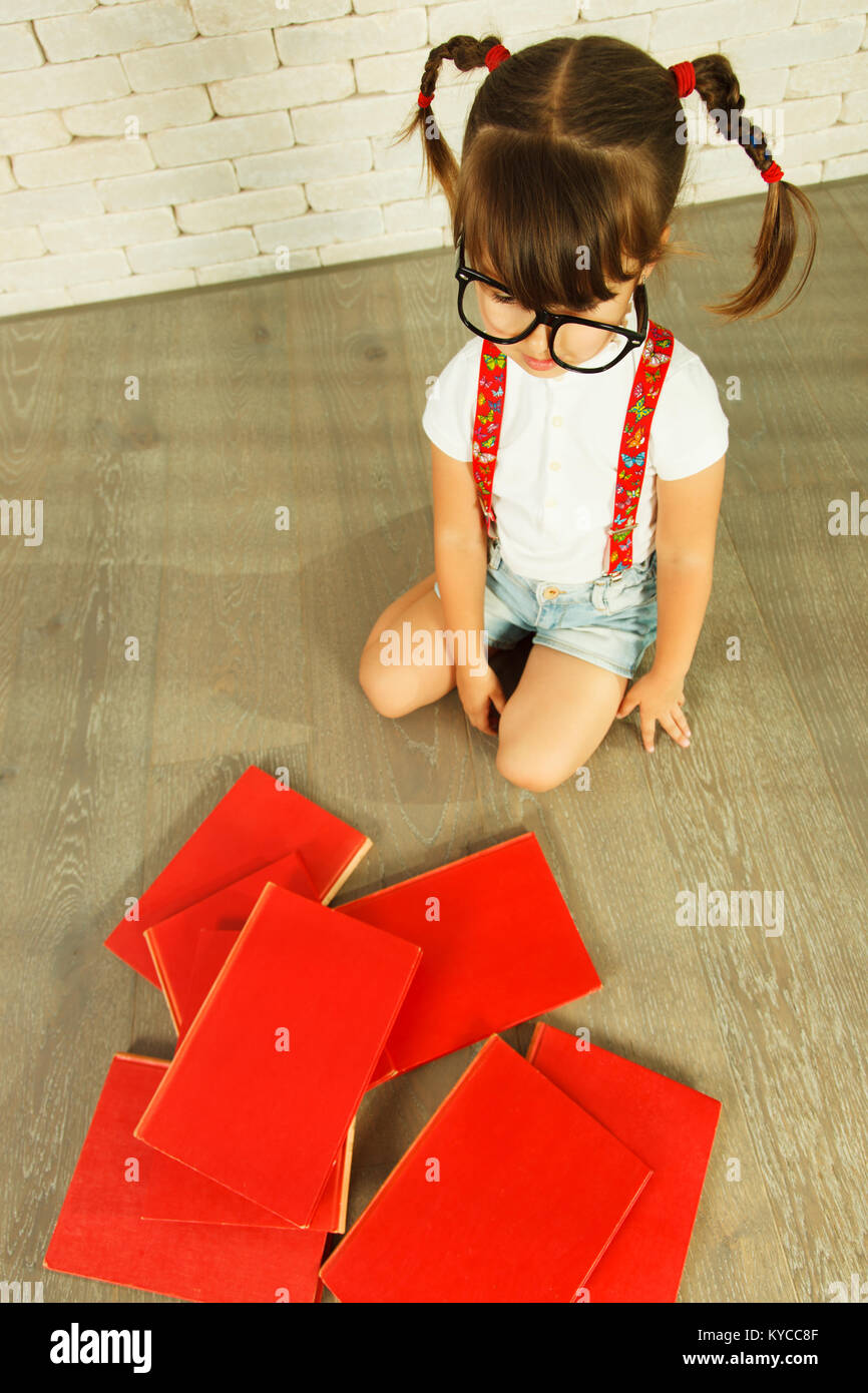 Preschooler girl with books on the floor Stock Photo - Alamy