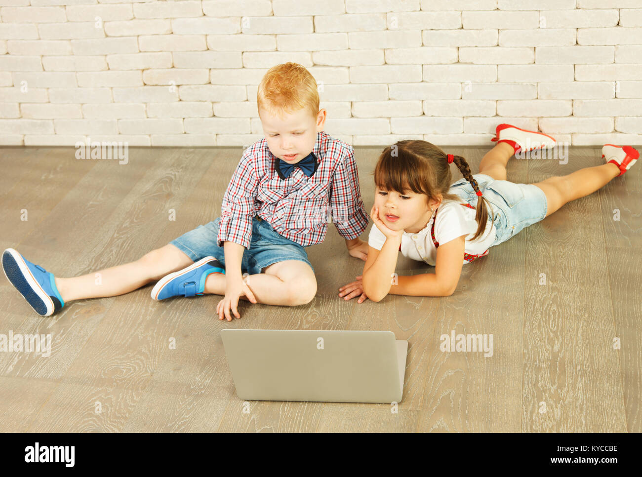 Preschoolers with laptop on the floor Stock Photo Alamy