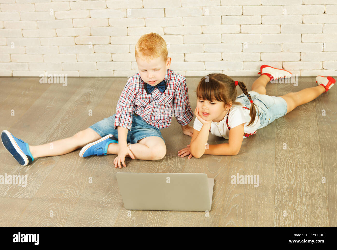 Preschoolers with laptop on the floor Stock Photo