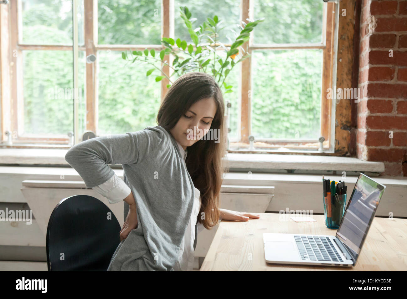 Young businesswoman feels sitting in office chair, woman
